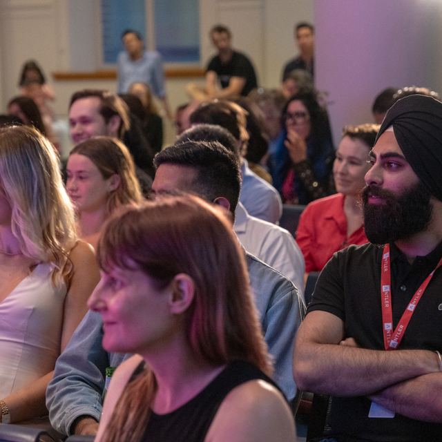 A seated audience watching a session at a Spark Festival event