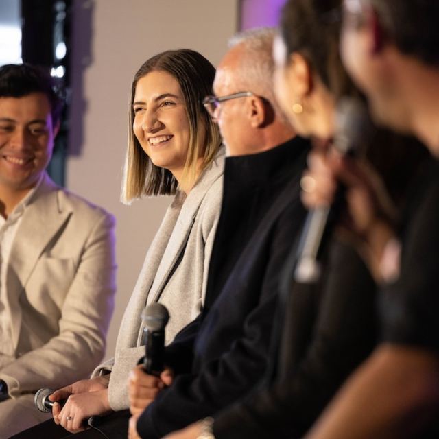 Five panellists seated with microphones during a Spark Festival panel