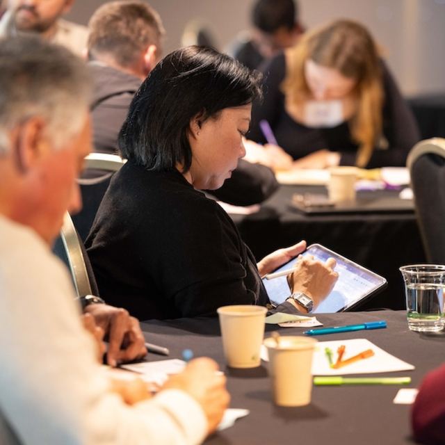 Participants working through worksheets around a table at a Spark Festival workshop
