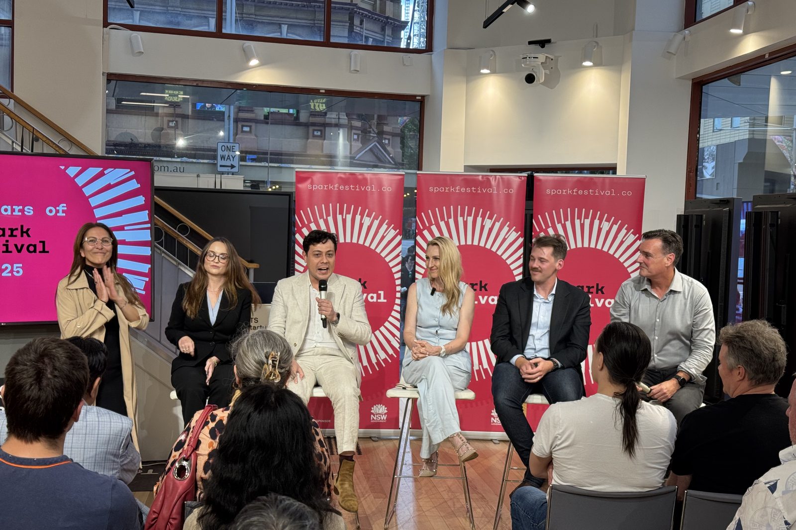A panel discussion in front of Spark Festival banners, with a seated audience