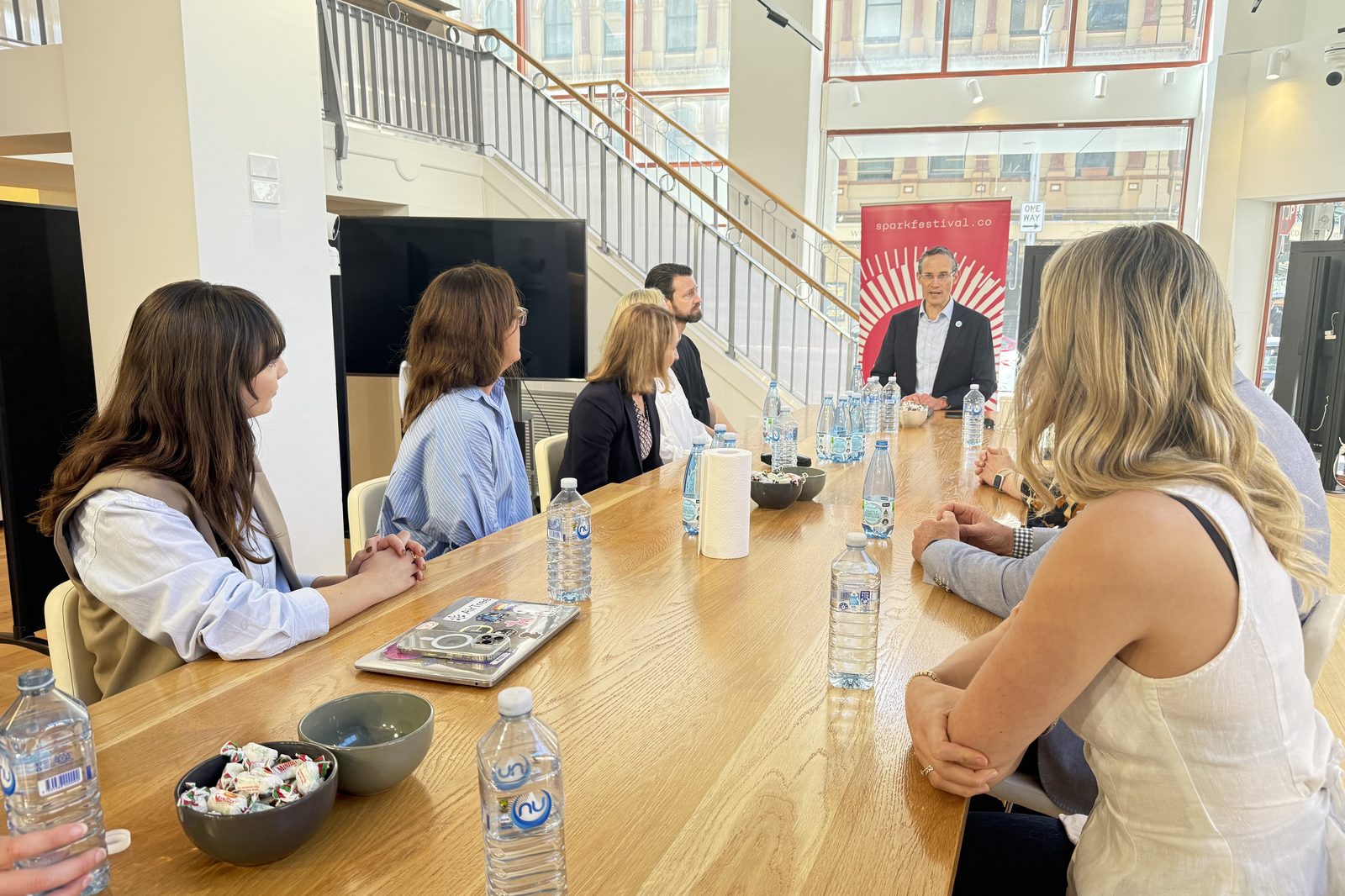 A roundtable discussion around a long table at a Spark Festival event